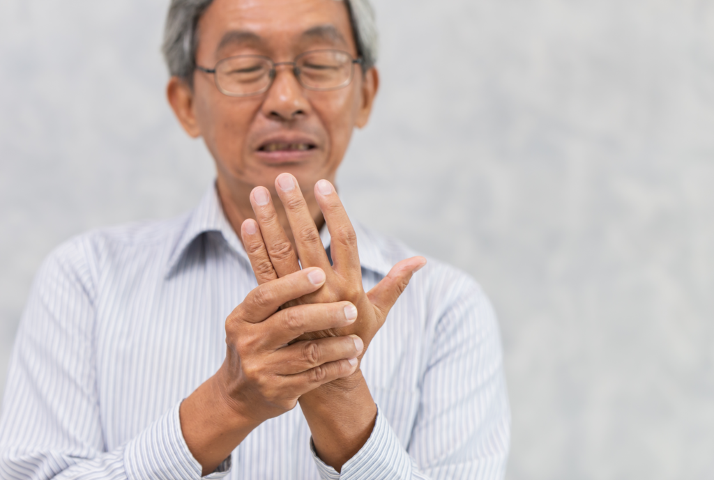 Elderly man with hand pain, rheumatoid arthritis, stiff joints in winter