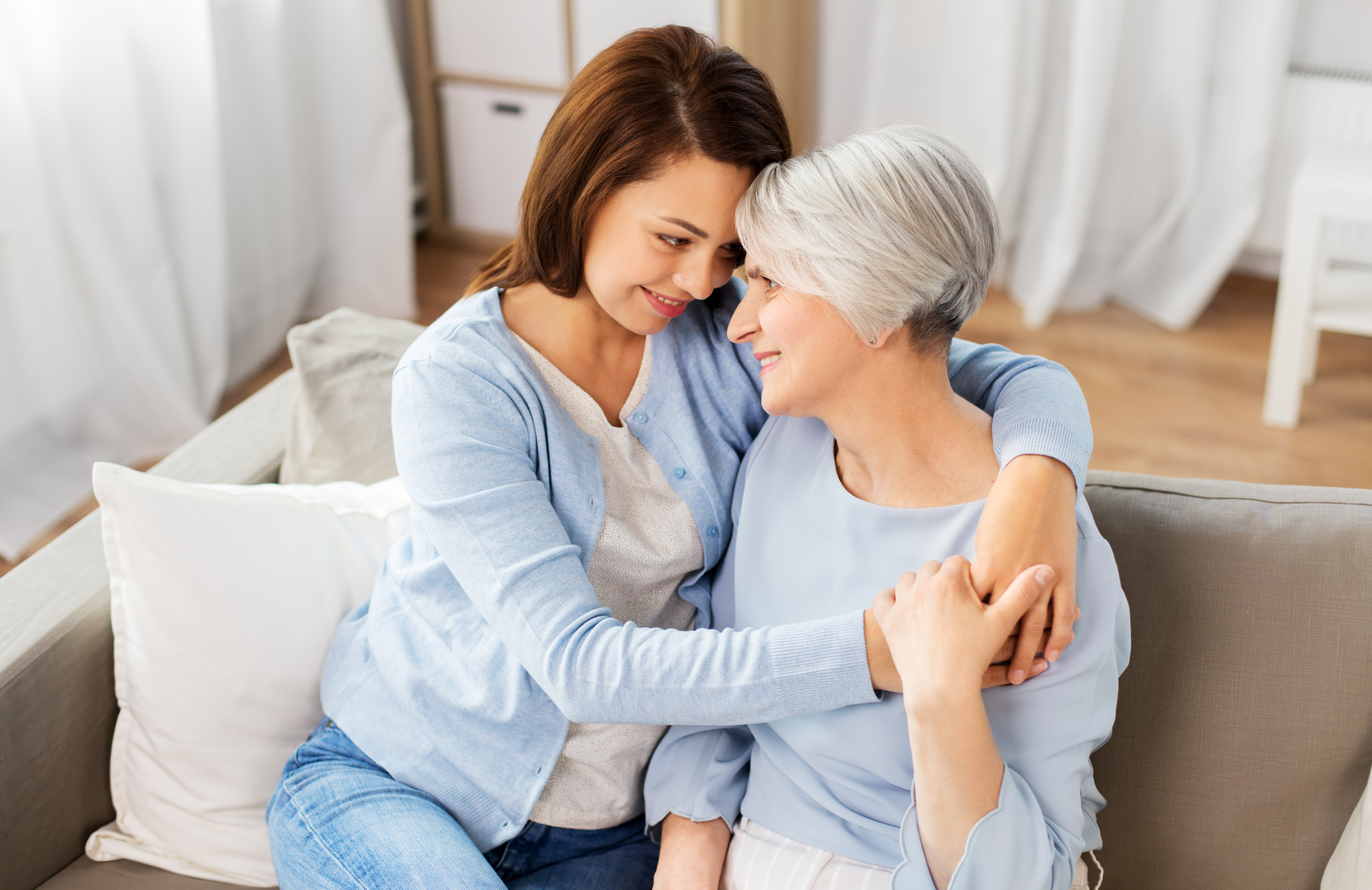 senior mother with adult daughter caring at home